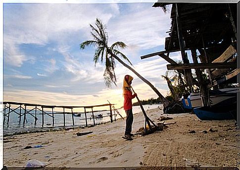 woman sweeping beach